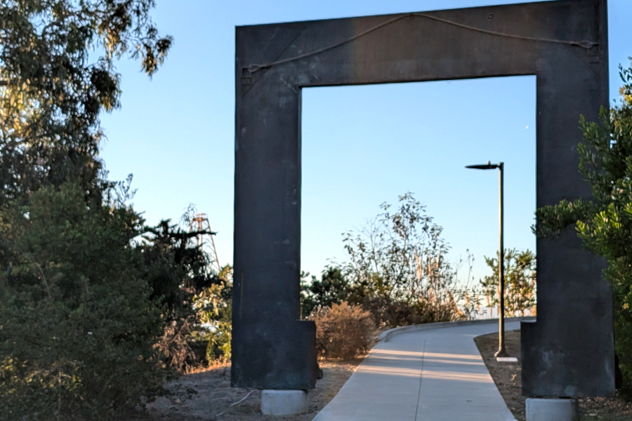 a path winds through a piece of art that looks something like the back of a huge picture frame with a rectangle cut out out of its center (allowing folks to walk through that frame)