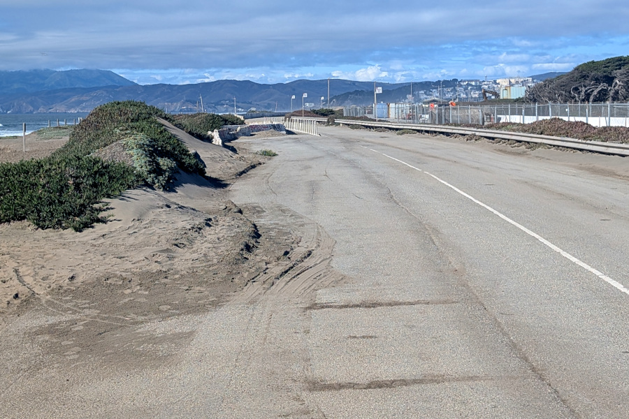 A stretch of abandoned highway. There's a beach off to the left, which explains why the highway is partly covered with drifting sand; other bits have eroded away.