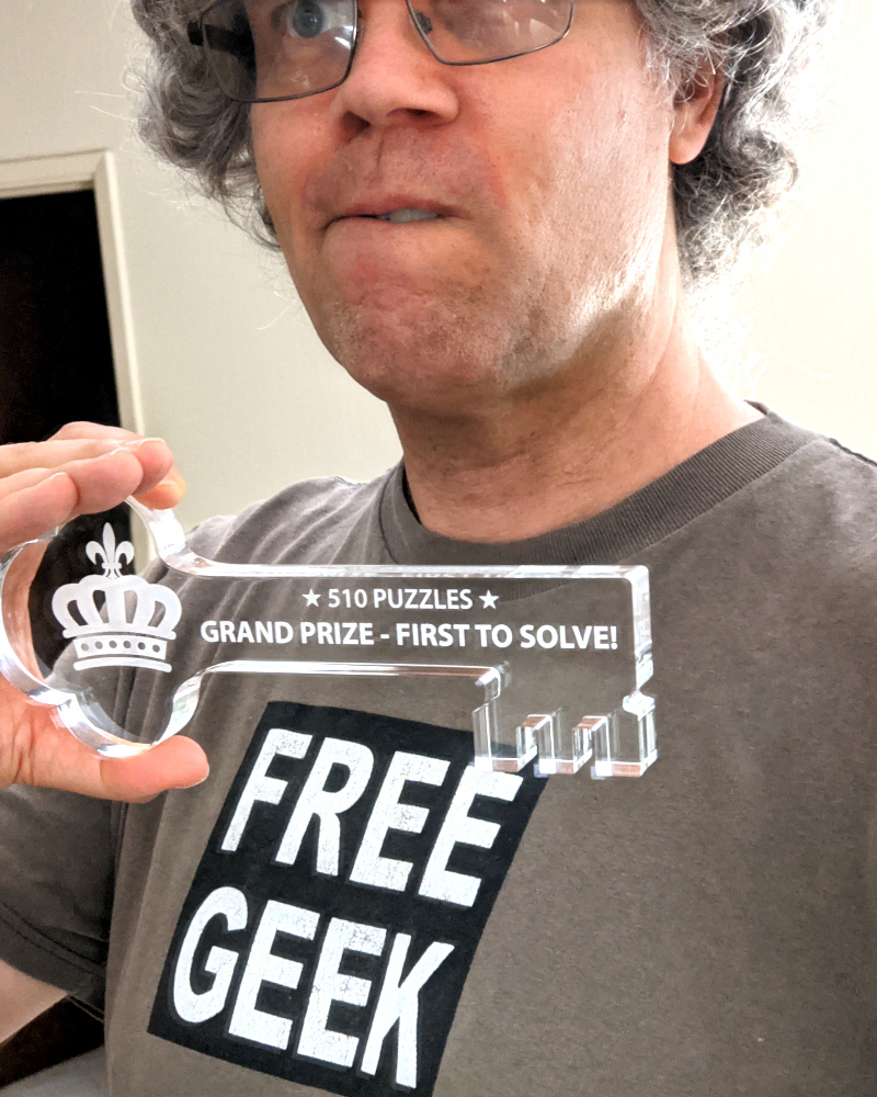 [picture: Selfie posing with nifty key etched with '★ 510 Puzzles ★ Grand Prize - First to Solve!']