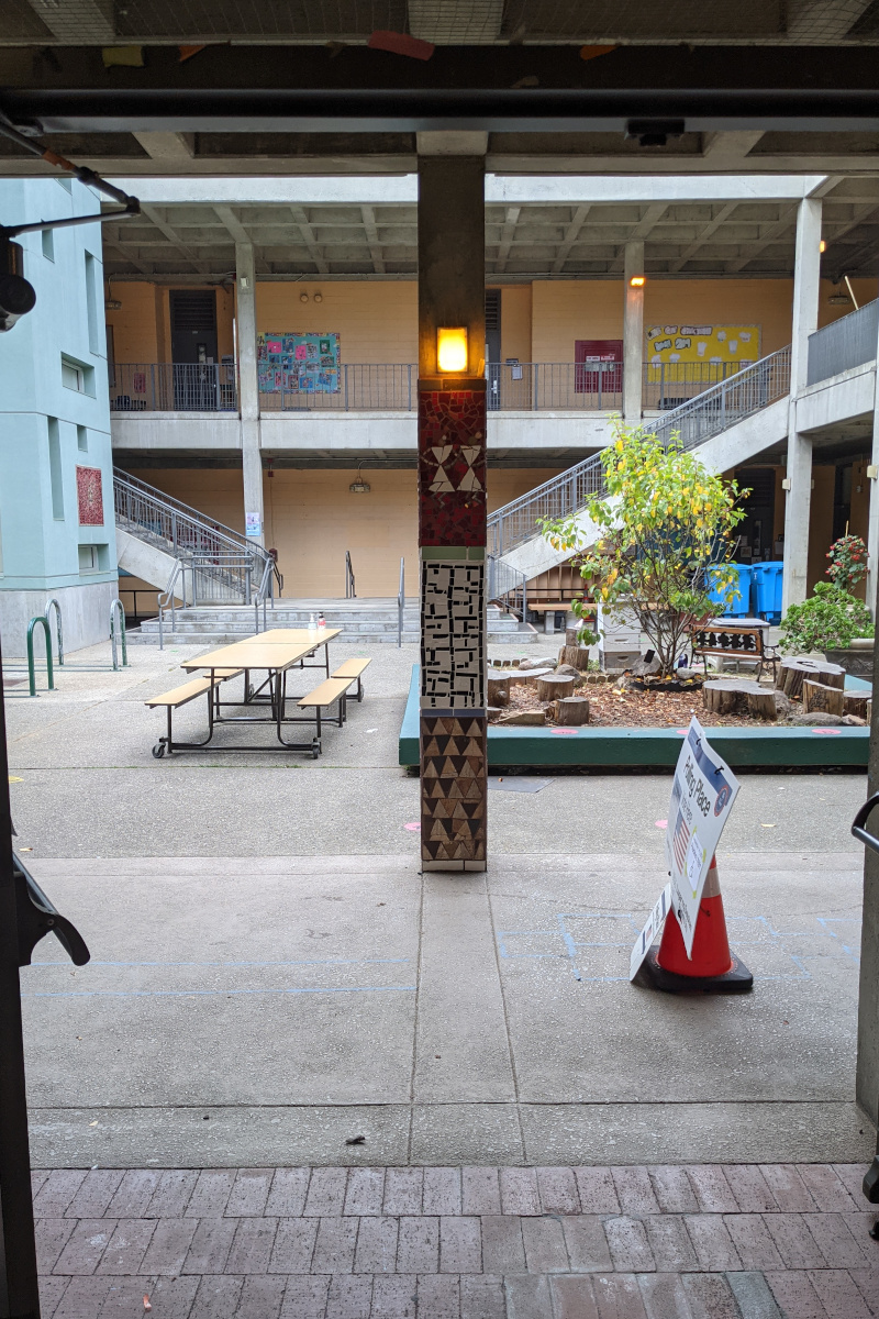 Courtyard at Grattan Elementary with tile-mural pillar decoration and a polling place sign