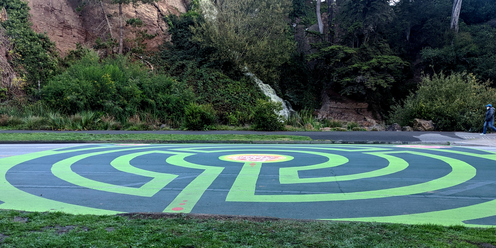 [photo: green labyrinth with flowers painted on the ground]