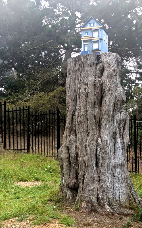 little model house atop a tall stump