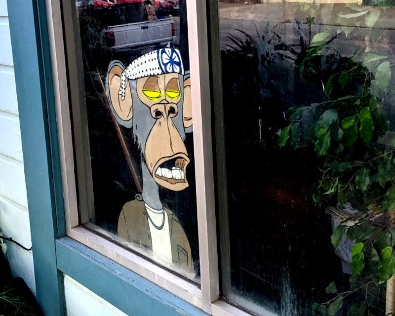 gallery window. leaning against the window is a cartoony picture cutout of a cartoon ape