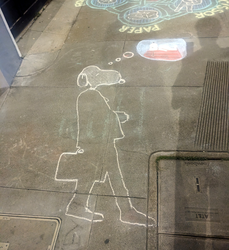Sidewalk chalk art: silhouette of a businessman with Snoopy's head has a thought bubble; in the thought bubble, Snoopy sleeps atop his doghouse