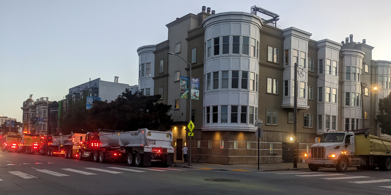 a line of dumptrucks on Stanyan Street and around the corner on Beulah waits to haul dirt dug up at Stanyan and Haight