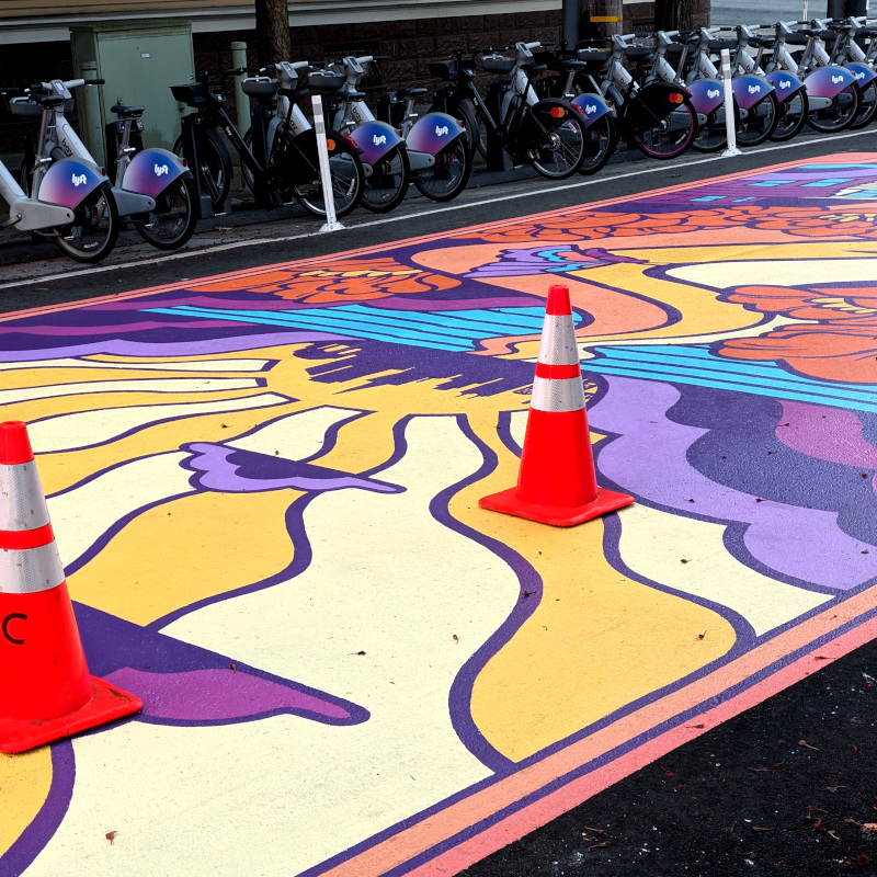 mysterious traffic cones atop a street mural