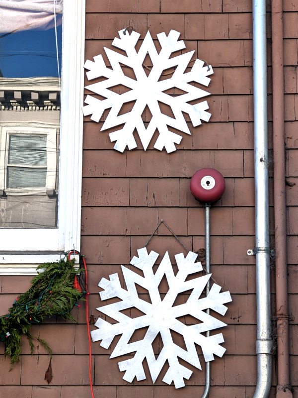side of a house with two identical "snowflake" decorations exhibiting eight-way symmetry