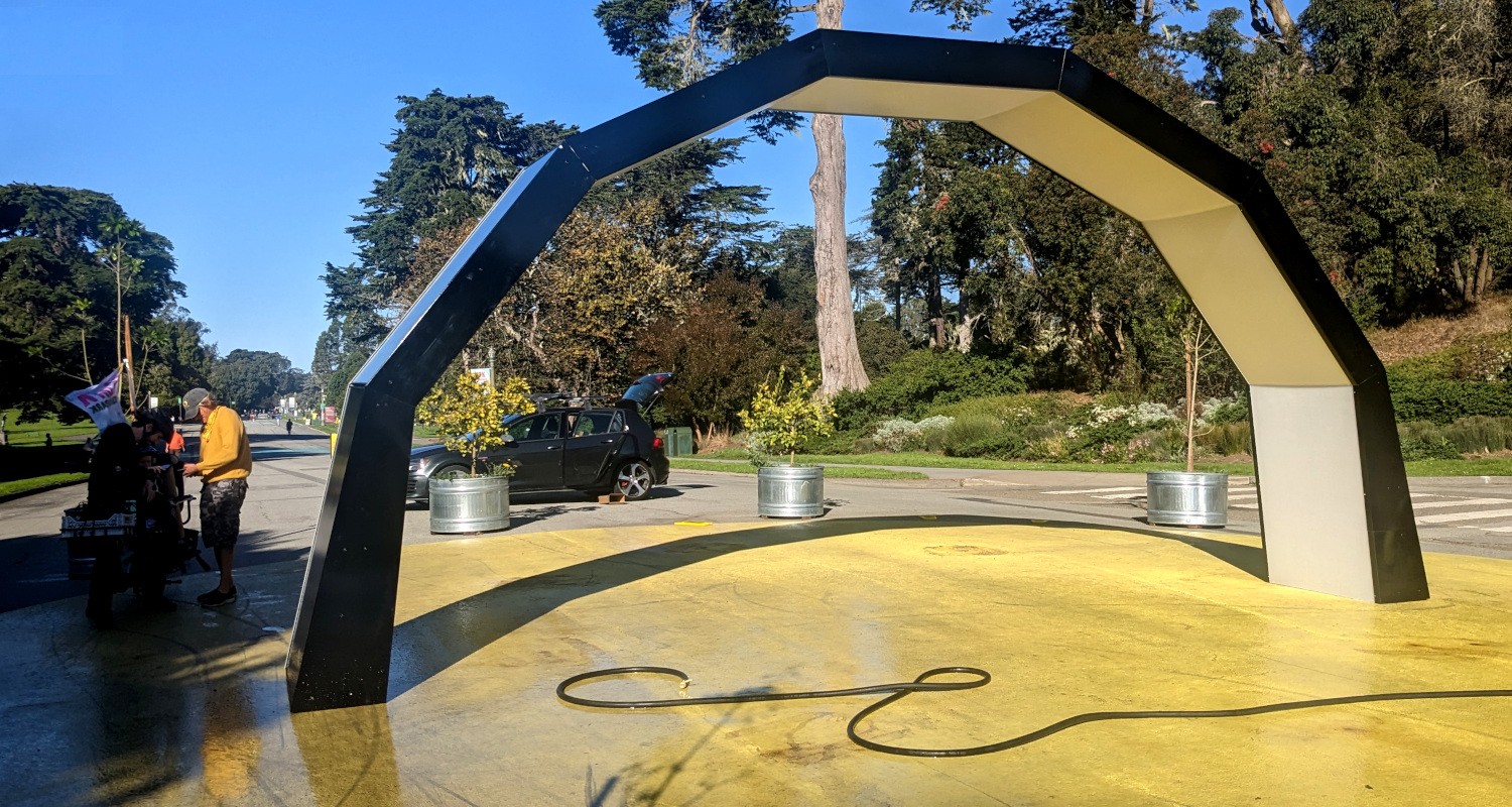 an arch in the middle of a road. also, a hose which I suppose was rinsing playa dust off of the solar panels?