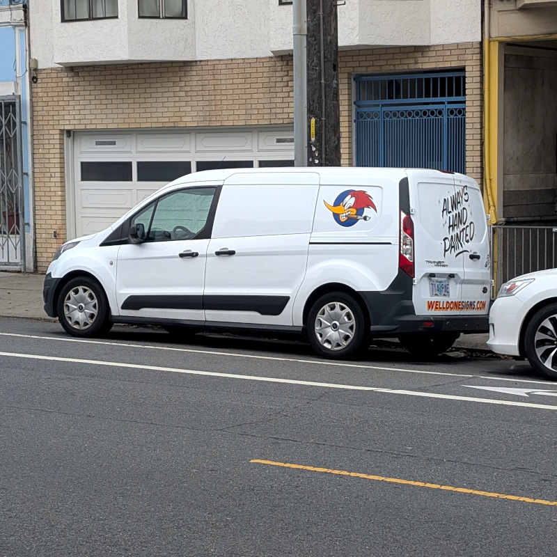 Sign painter's van with text promising 'Always hand painted' and a woodpecker logo