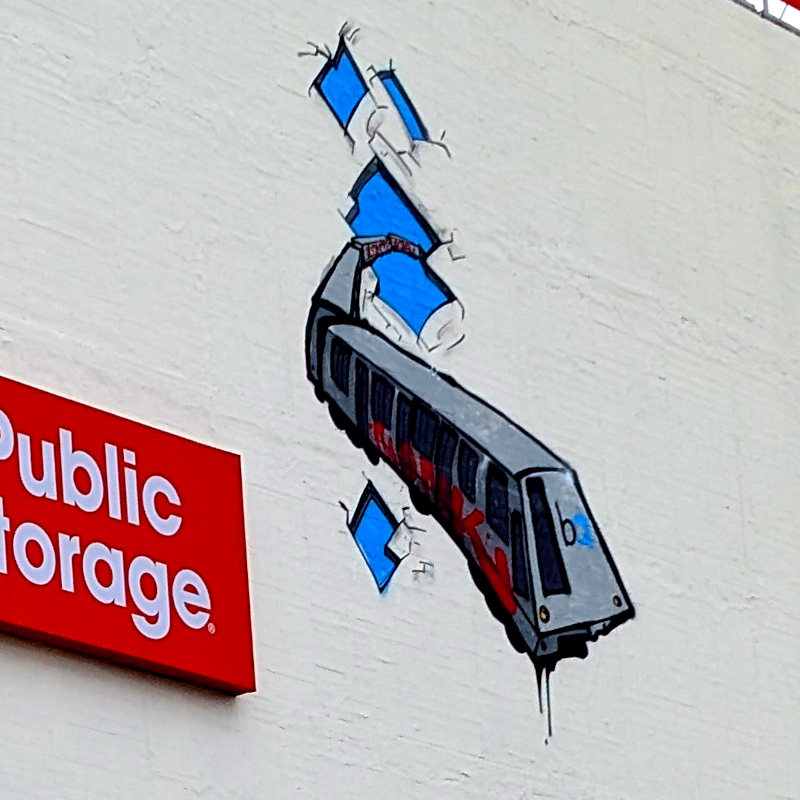 graffito on big wall over the old Lucky Penny. It depicts a BART train busting through the wall