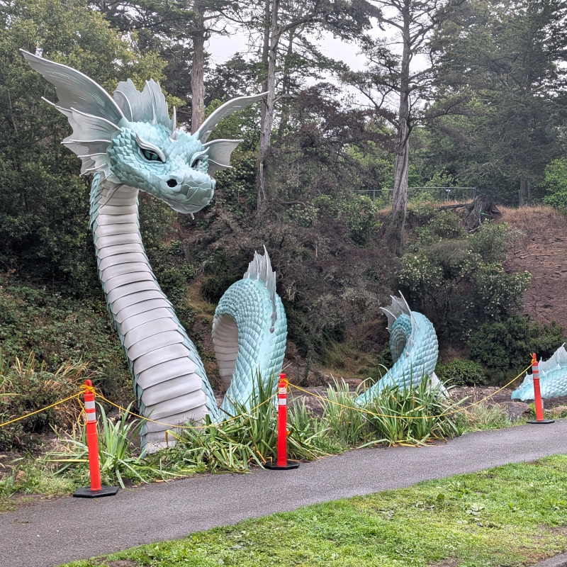 metallic-looking sea serpent statue wriggling in an empty pond