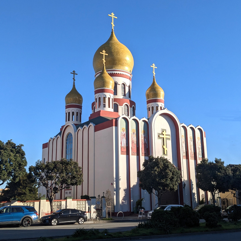 San Francisco's Holy Virgin Cathedral. big building. five golden onion domes. murals depicting saints. big orthodox crosses. 