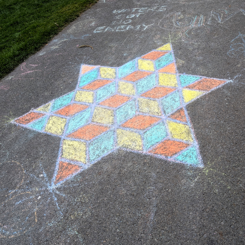 sidewalk chalk art: star of David, tessellated with colored diamonds to suggest a Q*bert-like mountain of cubes