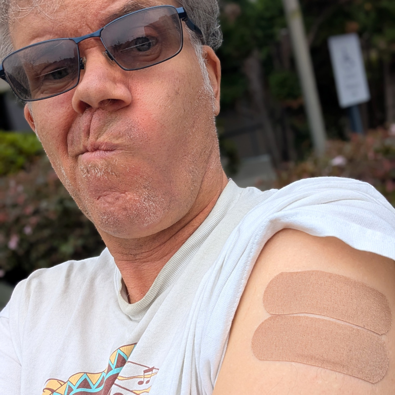 dude with his t-shirt arm rolled up to reveal a couple of band-aids. also it looks like he did a pretty haphazard job of shaving last night, lotsa stray whiskers. oh well