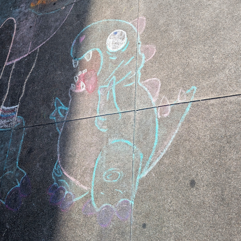 sidewalk with chalk art: zooming in on the baby dino
