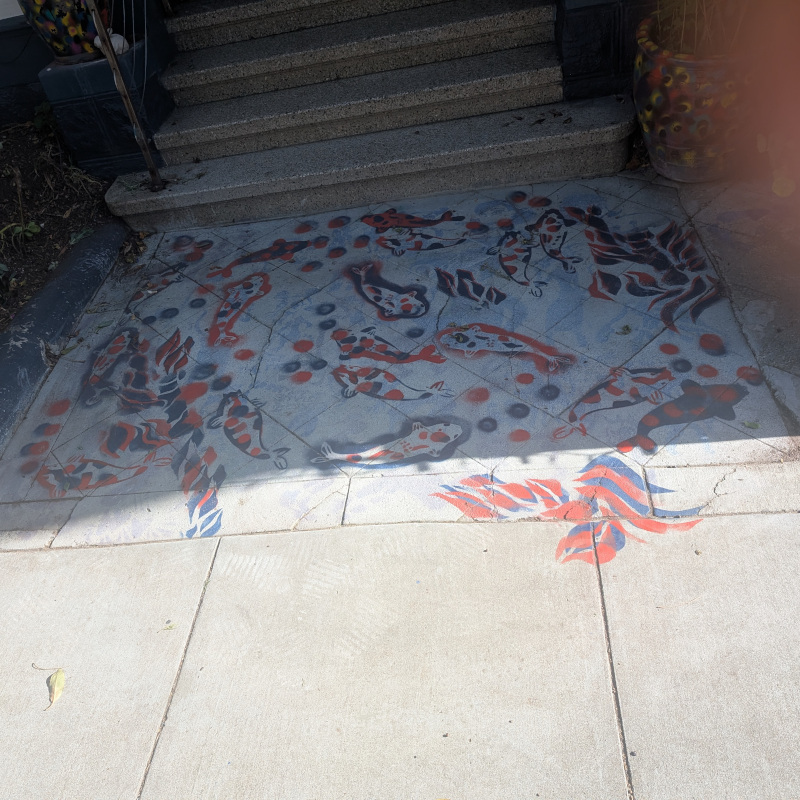 patch of pavement painted in orange and blue with carp, bubbles, and seaweed(?)