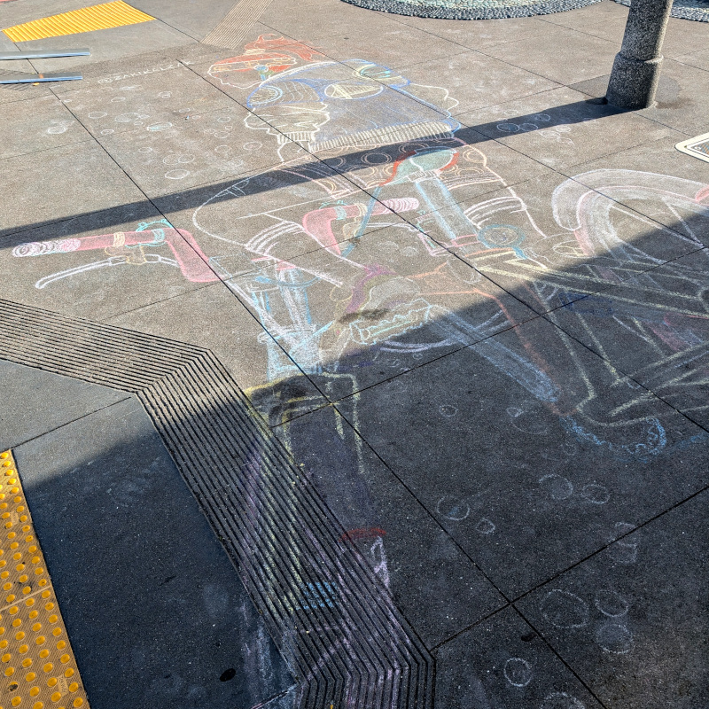 sidewalk chalk art: a bicyclist sits on a bike