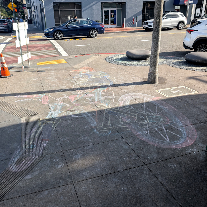 sidewalk chalk art: a bicyclist sits on a bike