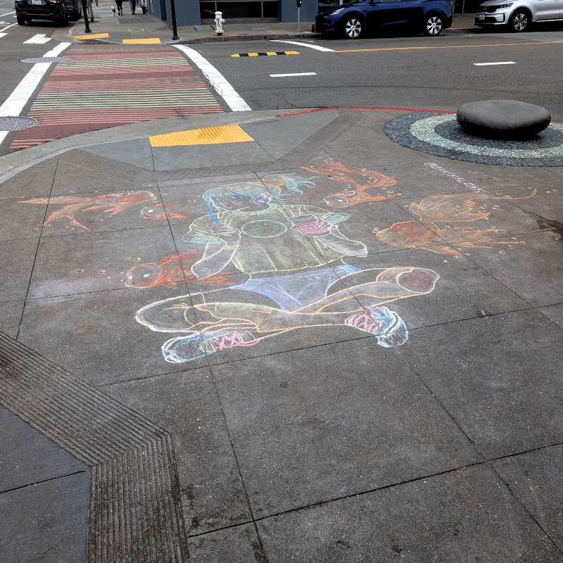 sidewalk chalk art: lady sits cross-legged blowing bubbles while surrounded by hovering giant baby-faced goldfish