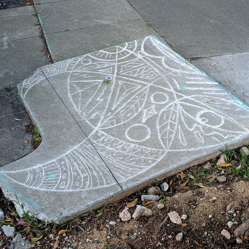 patch of sidewalk decorated with some geometric-ish patterns in chalk