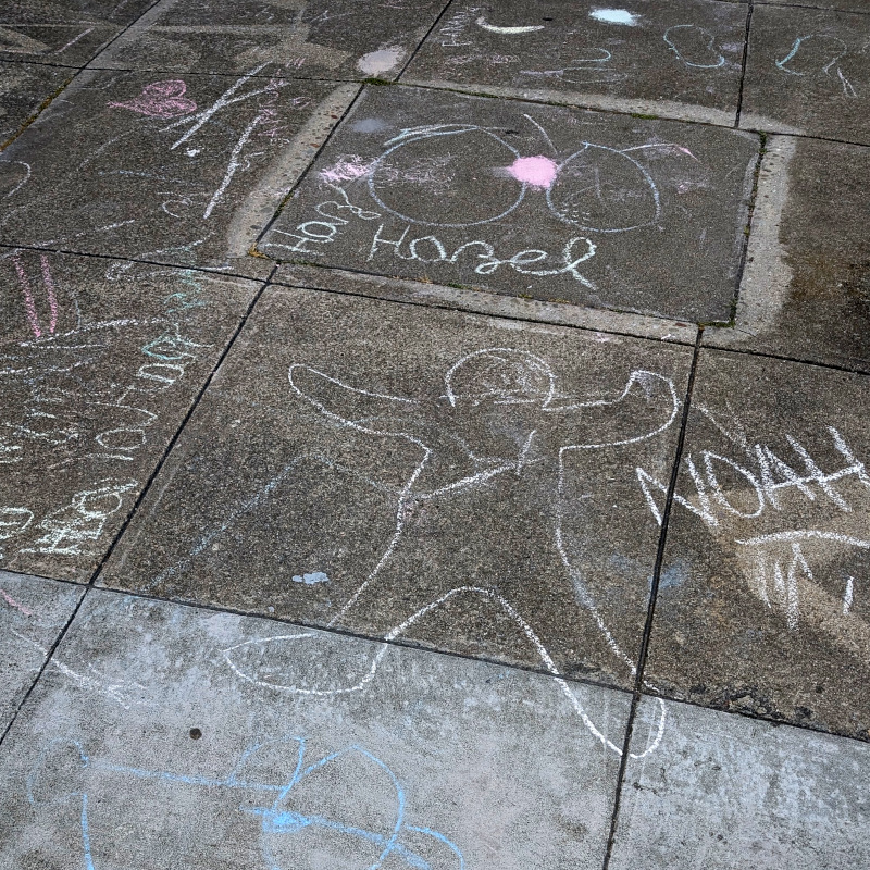 sidewalk chalk art: Probably the work of some kids with chalk and time on their hands. All such work is subject to interpretation but I think I see a heart and the outline of a small human (perhaps Noah?)