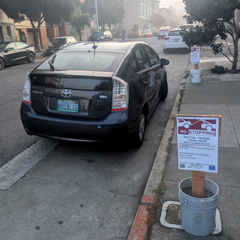 parked car with California license plate 'Hrd Alee' The license plate holder says 'volunteer / The Marine Mammal Center' (a sea mammal rescue place up in Marin County)