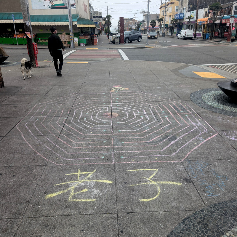 sidewalk chalk art: overall, it's a labyrinth shaped like an octogon. on top is Pac-Man