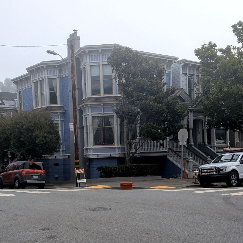 blue house with a lot of new architectural ornament on it. Also, there's a footrest out in the street