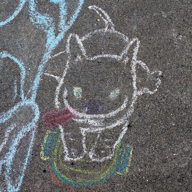 sidewalk chalk art: zooming in on skateboarding pet. I'm not 100% sure whether it's a cat or dog. It's definitely sticking its tongue out tho
