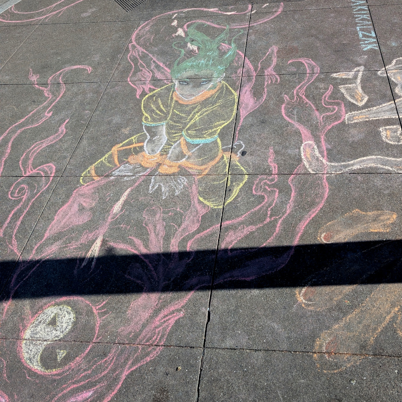 sidewalk chalk art: zooming in on the dragon rider. green hair, yellow outfit, stoic facial expression