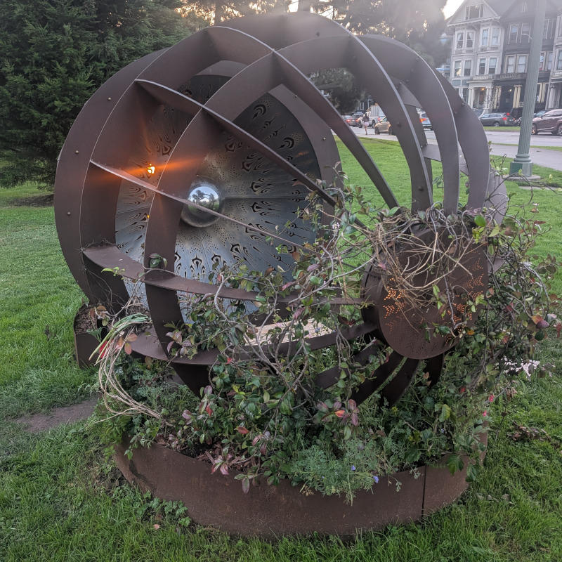 metal sculpture with some flowering vines crawling on it