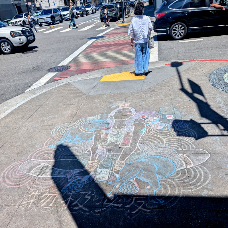 sidewalk chalk art: someone sits in lotus position among clouds. they are surrounded by a looooong dog and other animal pals. There's a bottle in front of them