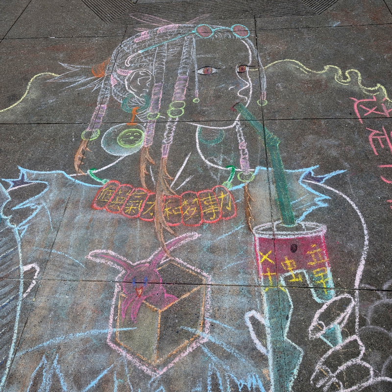 sidewalk chalk art: zooming in on face of lady canned beverage. She has a Doraemon-reminiscent earring; that's the logo of the nearby deli. There's some Chinese text on her necklace which, alas, I don't understand well enough to enter