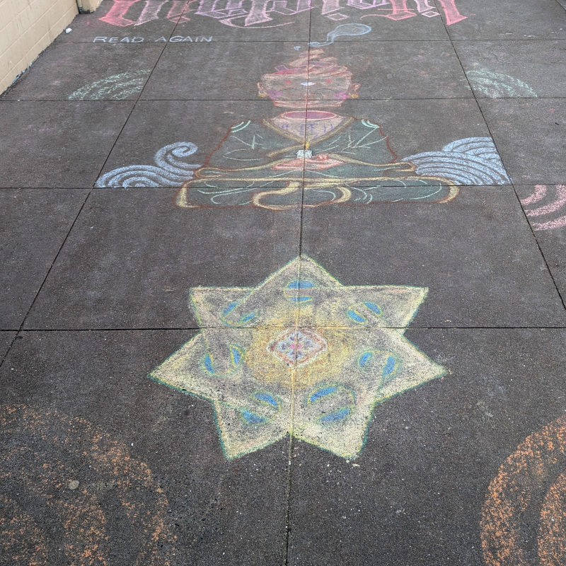 sidewalk chalk art: a seven pointed star that is kinda solid kinda not in an Escheresque way. Above is someone sitting in Lotus position but their head is levitating somewhat separate