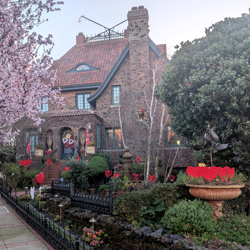 mansion with a big front yard decorated with many, many hearts. Also in view is a splash of plum blossoms